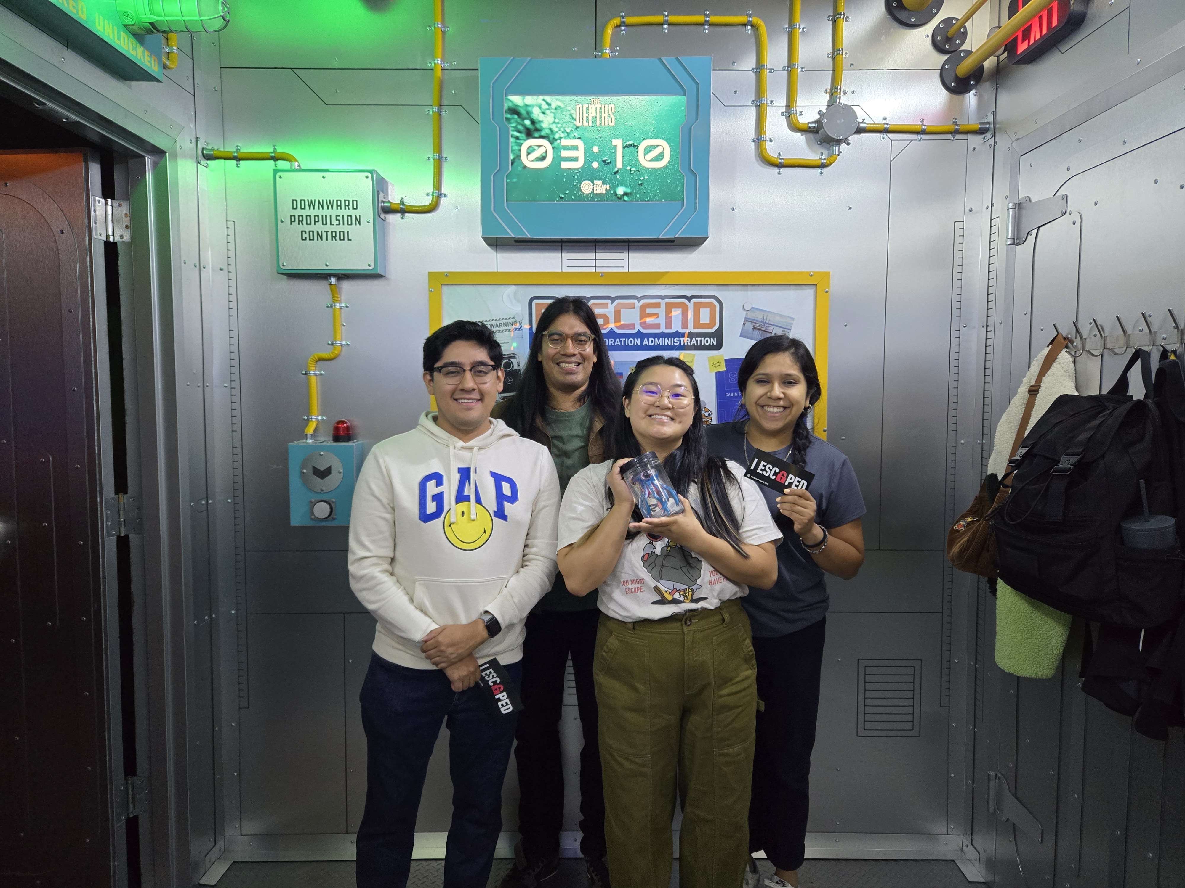 four people in a submarine-themed room
