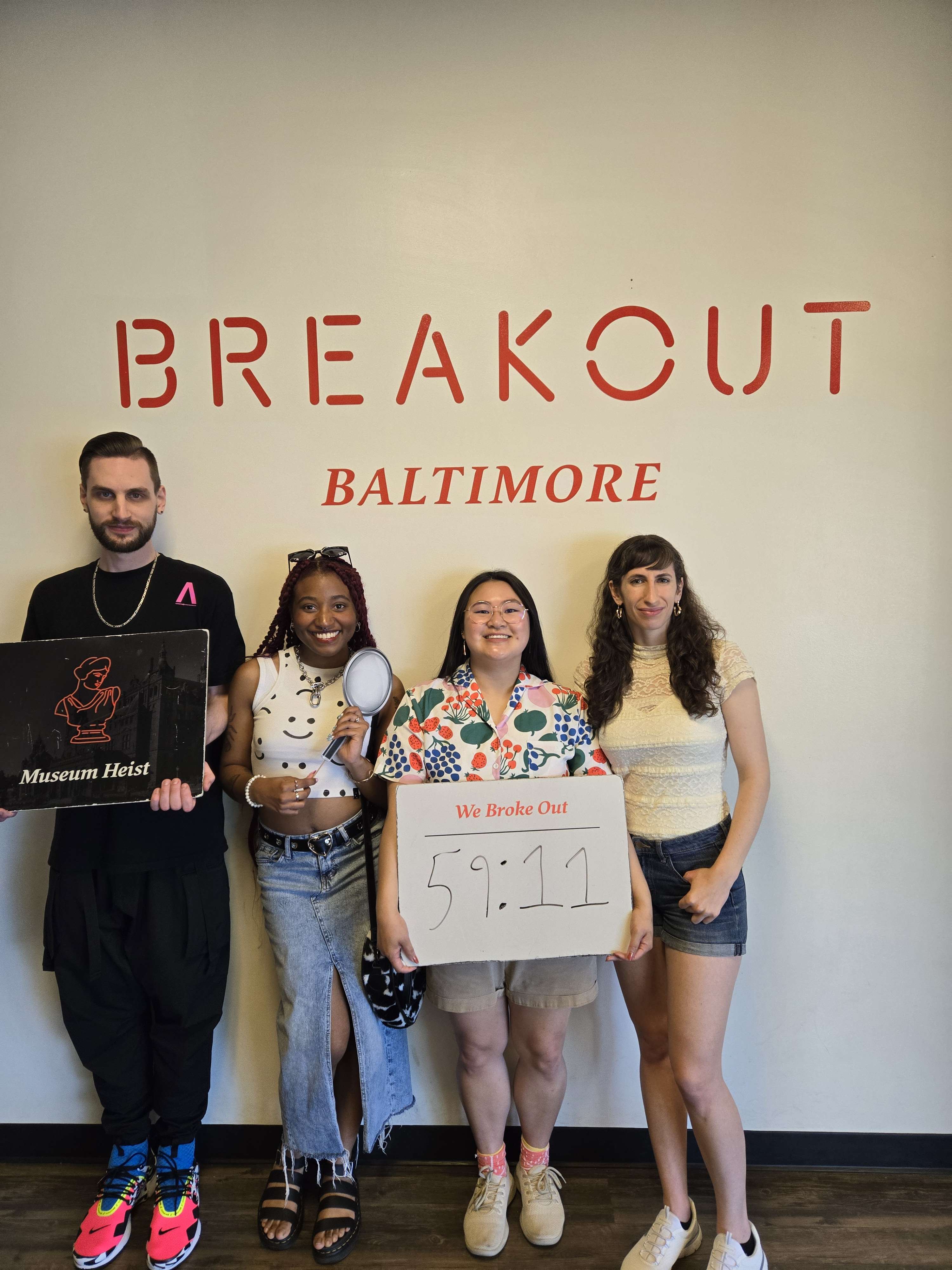 one boy and three girls smiling for a photo against a white wall